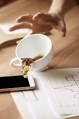 Image showing Coffee in white cup spilling on the table in the morning working day at office table