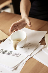 Image showing Coffee in white cup spilling on the table in the morning working day at office table