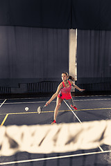 Image showing Young woman playing badminton at gym