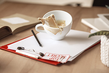 Image showing Coffee in white cup spilling on the table in the morning working day at office table