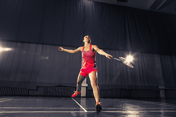 Image showing Young woman playing badminton at gym