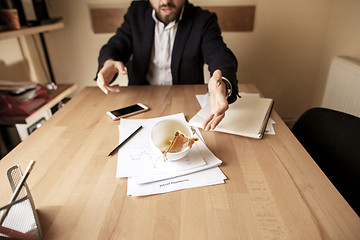 Image showing Coffee in white cup spilling on the table in the morning working day at office table