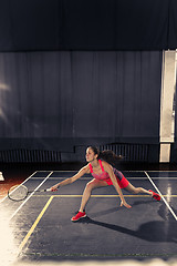 Image showing Young woman playing badminton at gym