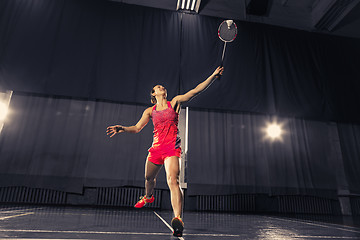 Image showing Young woman playing badminton at gym