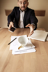 Image showing Coffee in white cup spilling on the table in the morning working day at office table