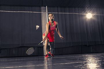 Image showing Young woman playing badminton at gym