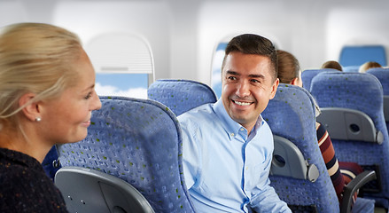 Image showing happy passengers talking in plane