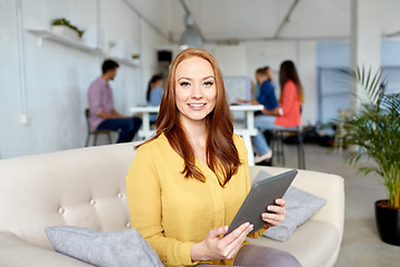 Image showing redhead woman with tablet pc working at office