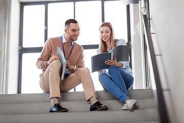 Image showing man and woman with folders at office stairs