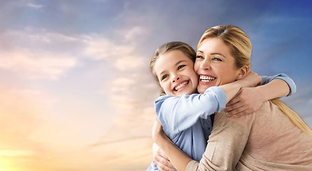 Image showing happy smiling mother hugging daughter over sky