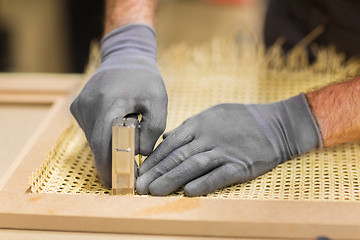 Image showing assembler with staple gun making furniture