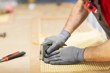 Image showing assembler with staple gun making furniture