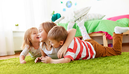 Image showing happy little kids lying on floor or carpet