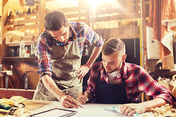 Image showing workmen with tablet pc and blueprint at workshop