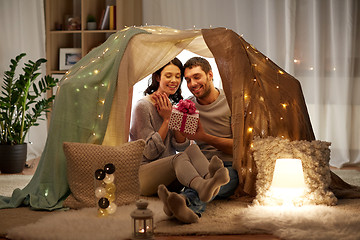 Image showing happy couple with gift box in kids tent at home