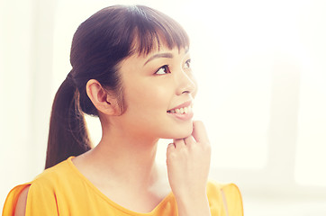 Image showing happy asian young dreaming woman face at home