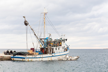 Image showing Fishing boat mooring at the pier in mediterranean sea.