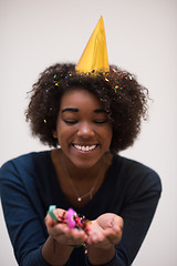 Image showing African American woman blowing confetti in the air