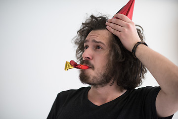 Image showing Portrait of a man in party hat blowing in whistle