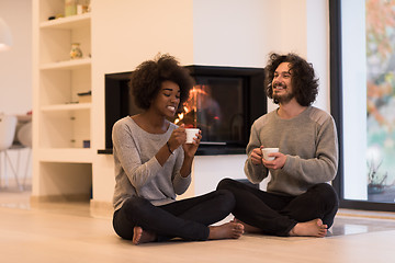 Image showing multiethnic couple  in front of fireplace