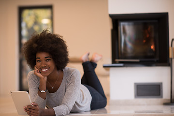 Image showing black women using tablet computer on the floor