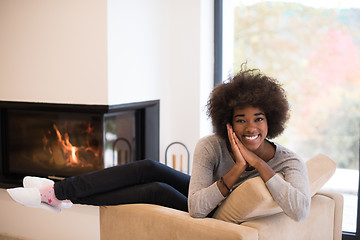 Image showing black woman in front of fireplace