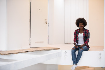 Image showing black woman sitting on stairs at home