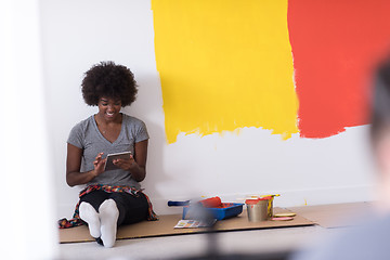 Image showing back female painter sitting on floor