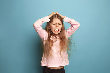 Image showing The cry. Teen girl on a blue background. Facial expressions and people emotions concept