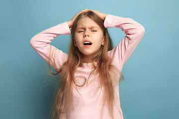 Image showing The headache. Teen girl on a blue background. Facial expressions and people emotions concept