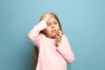 Image showing The headache. Teen girl on a blue background. Facial expressions and people emotions concept