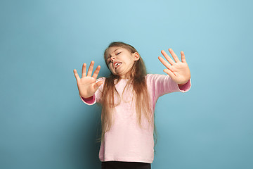 Image showing The disgust. Teen girl on a blue background. Facial expressions and people emotions concept