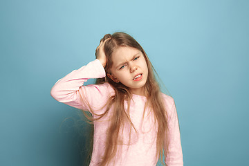 Image showing The headache. Teen girl on a blue background. Facial expressions and people emotions concept