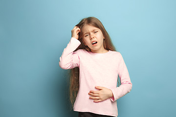 Image showing The abdominal pain. Teen girl on a blue background. Facial expressions and people emotions concept