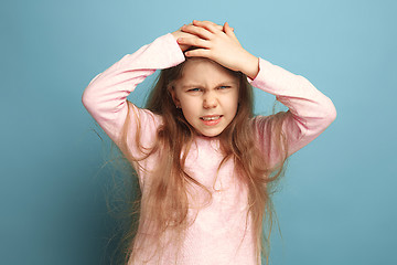 Image showing The headache. Teen girl on a blue background. Facial expressions and people emotions concept