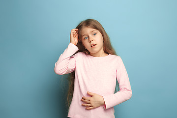 Image showing The abdominal pain. Teen girl on a blue background. Facial expressions and people emotions concept