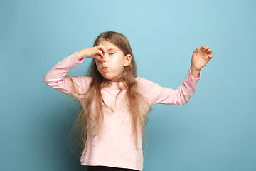 Image showing The disgust. Teen girl on a blue background. Facial expressions and people emotions concept