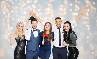 Image showing happy friends with party props posing over lights