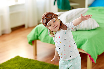 Image showing happy little girl in pilot hat playing at home