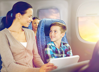 Image showing happy family with tablet pc sitting in plane