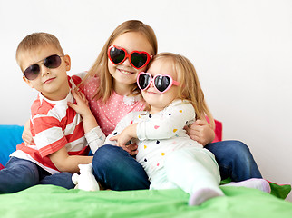 Image showing happy little kids in sunglasses at home