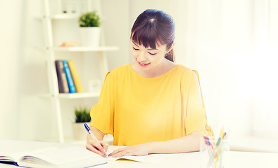 Image showing happy asian young woman student learning at home