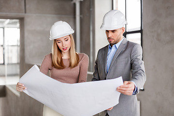 Image showing architects with blueprint and helmets at office