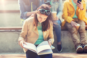 Image showing high school student girl reading book outdoors