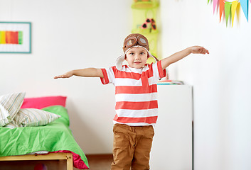 Image showing happy little boy in pilot hat playing at home