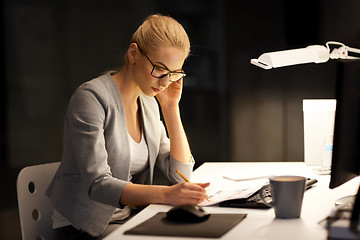 Image showing businesswoman with papers working at night office