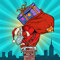 Image showing Santa Claus with bag of presents climbing into the chimney