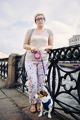 Image showing Aged woman with dog on embankment