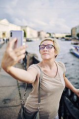 Image showing Senior female taking selfie on embankment