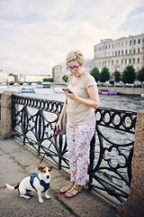 Image showing Aged woman with dog on embankment